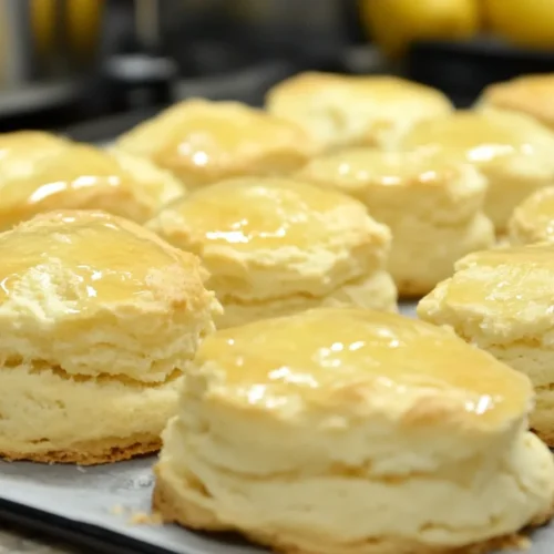 Freshly baked lemonade scones with a golden crust, served on a plate.