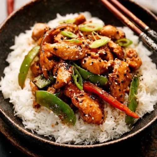 Plate of Take-Out Style Black Pepper Chicken with bell peppers served over white rice