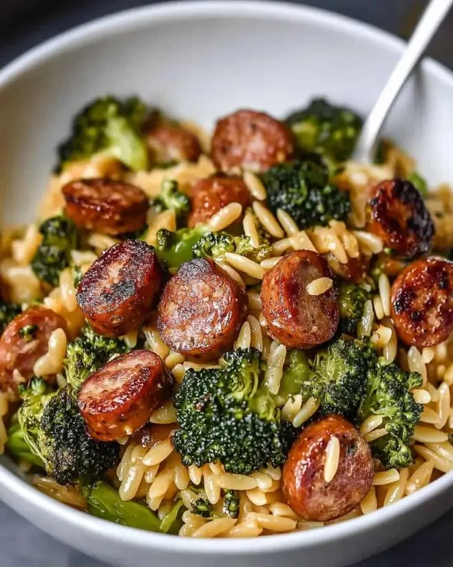Chicken Sausage and Broccoli Orzo served in a bowl with fresh herbs.