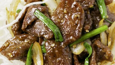 Plate of flavorful Mongolian Beef served with vegetables and rice.